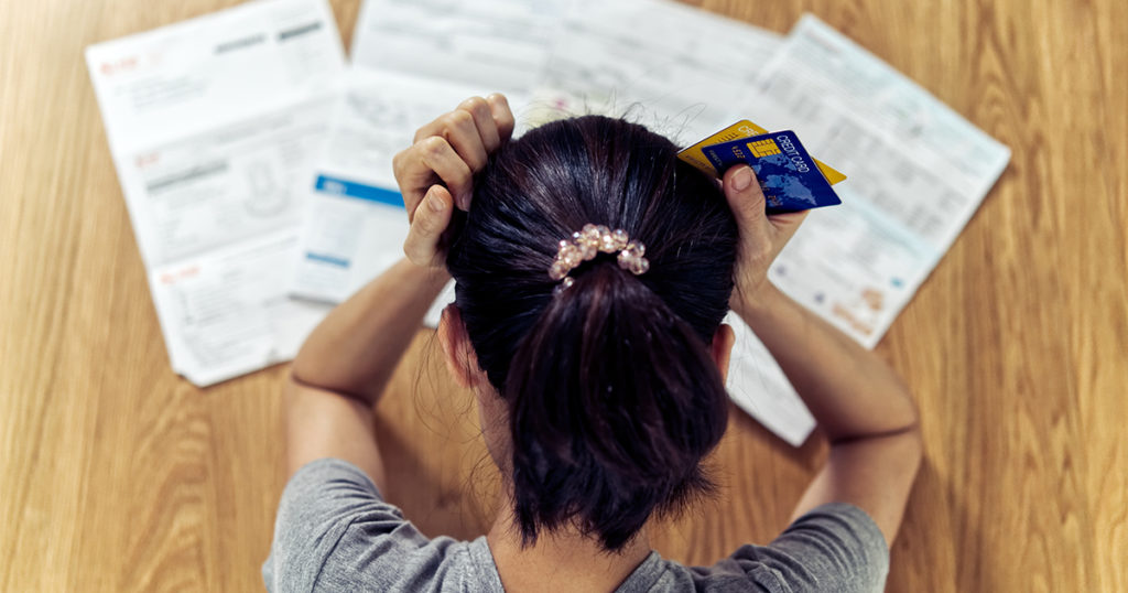 Image of woman stressed from paying bills.