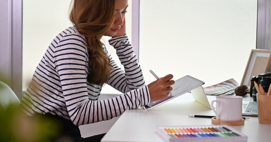 image of woman sketching on an ipad